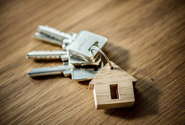 Porte clé en forme de maison et 3 clés modernes représentant l'investissement immobilier